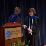 Faculty member presents former provost Davis with a pin